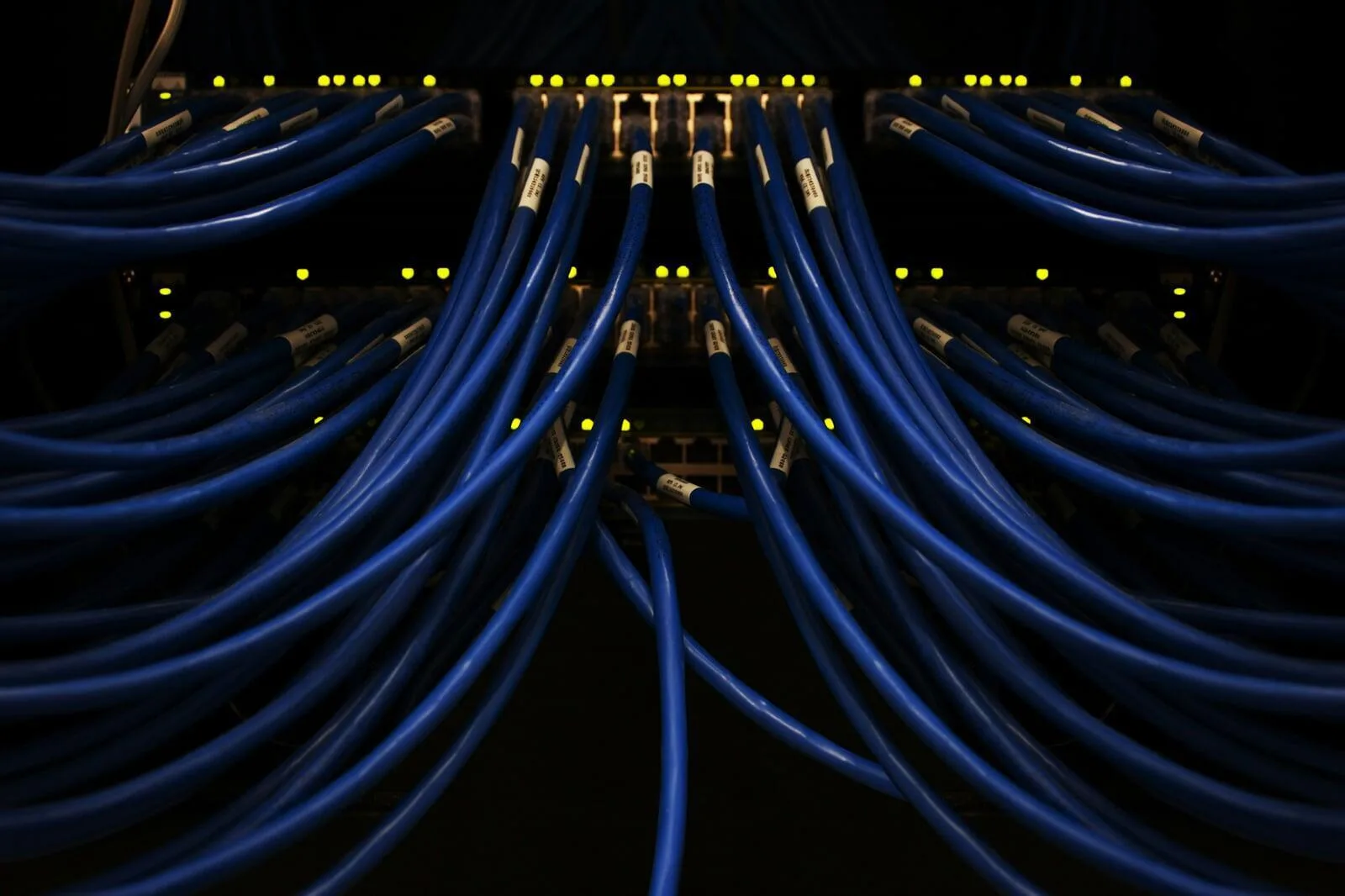 Cableado de red en rack técnico con luces de conectividad.
